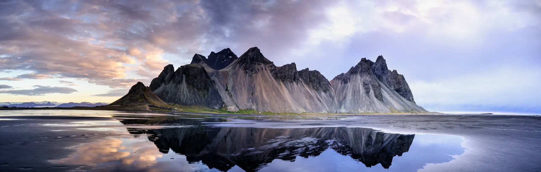 Vestrahorn mountain reflected in black sand water